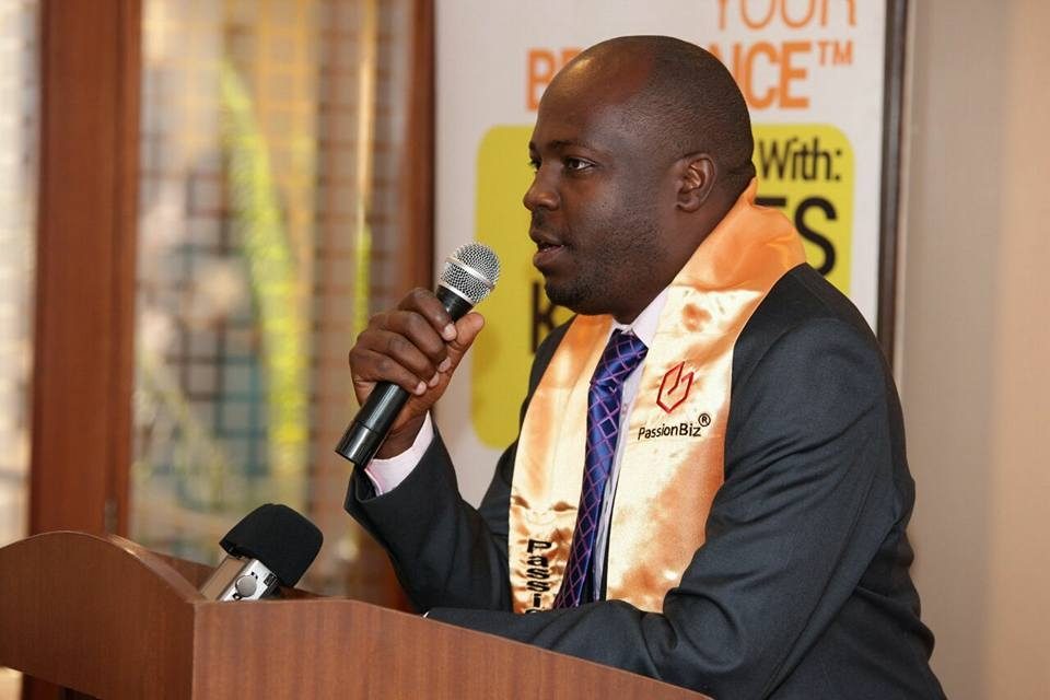 Eric Obwaka addressing an audience from a podium
